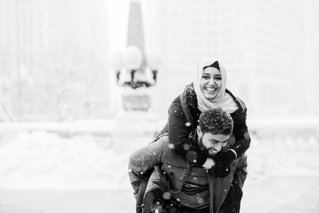 A happy smiling wife gets a piggyback ride during a blizzard in Chicago. 