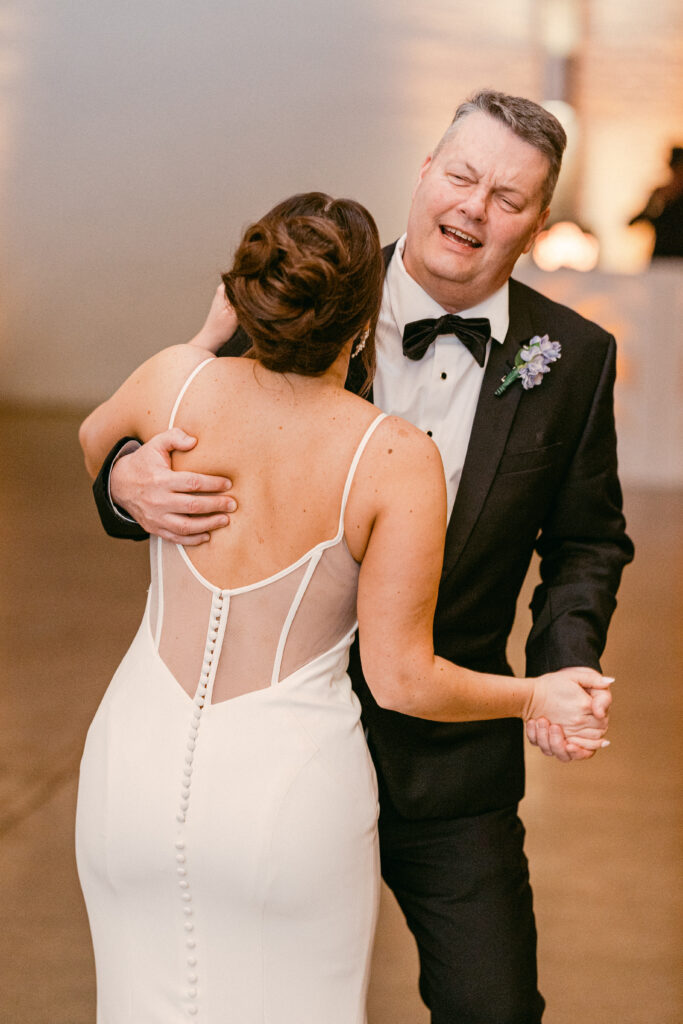The father of the bride wraps his daughter up during their special dance. 