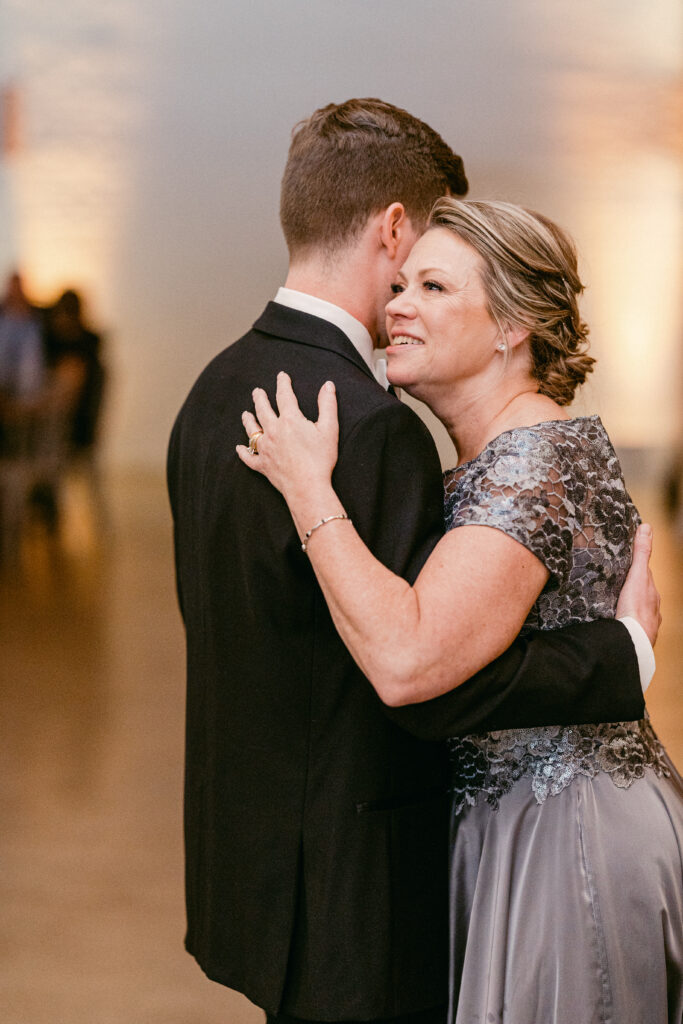 The mother of the groom embraces her son for a special dance.